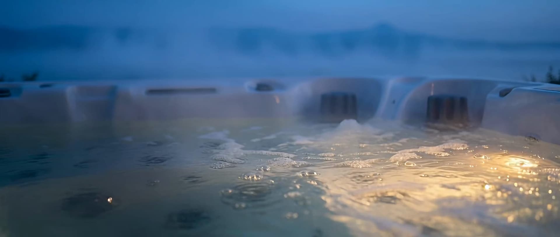 Warm beleuchtetes, blubberndes Wasser in einem Whirlpool, nah an der Oberfläche